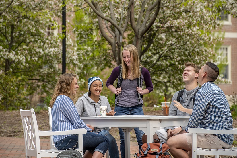 A group of students at an outdoor table on campus