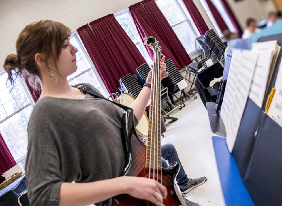 A photo of a music student playing a guitar