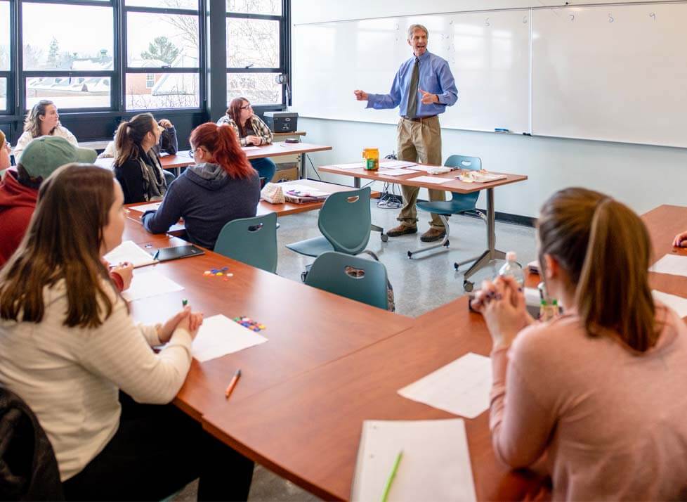 A photo of a classroom of students listening to a teacher