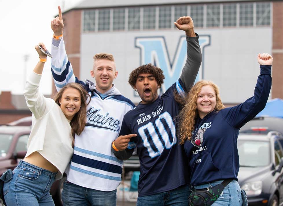 A photo of four people at tailgating before a football game