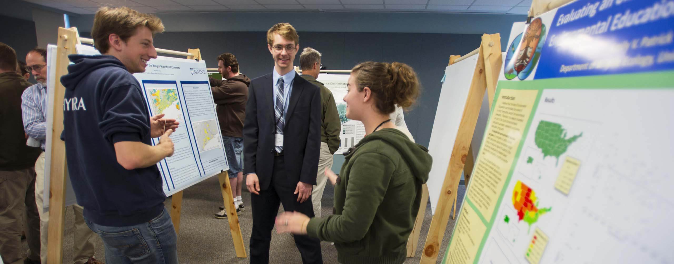 A photo of three people standing next to posters