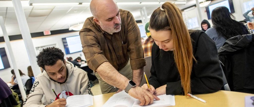 A photo of a professor helping a student with math work