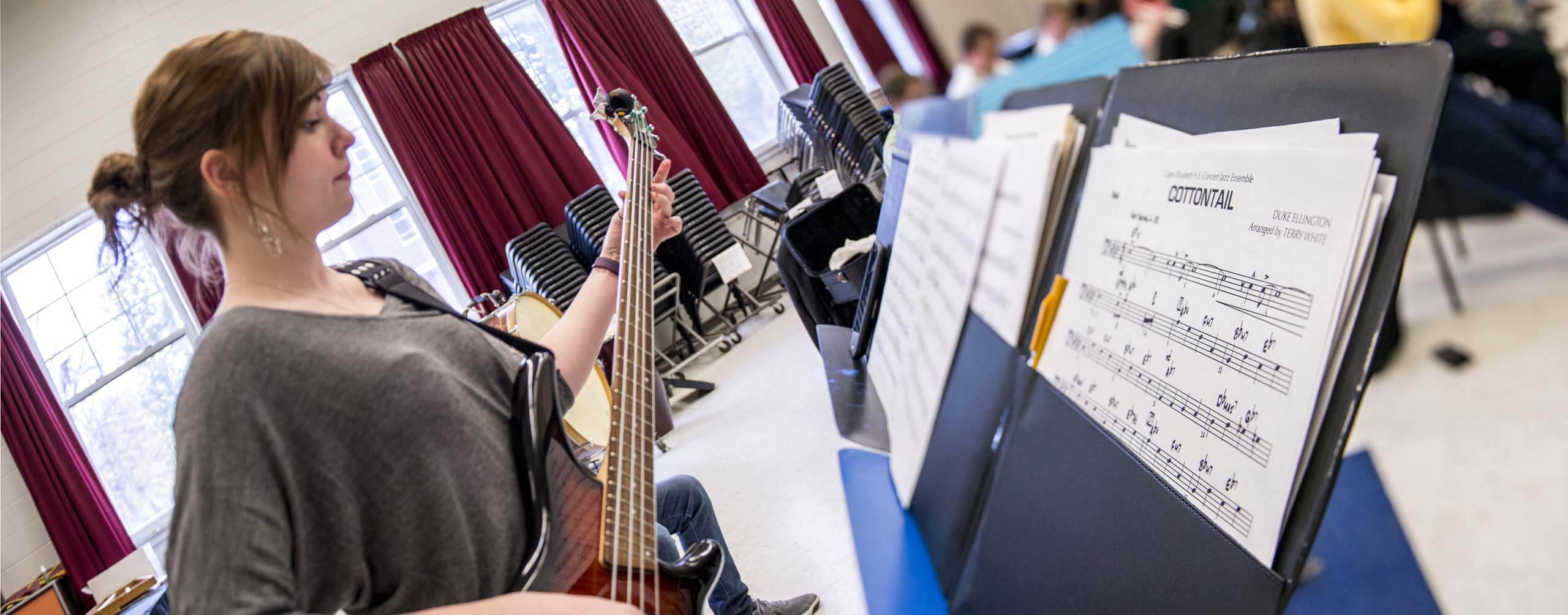 A photo of a music student playing a guitar