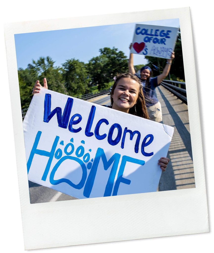 A photo of a person holding a sign that reads "Welcome Home"
